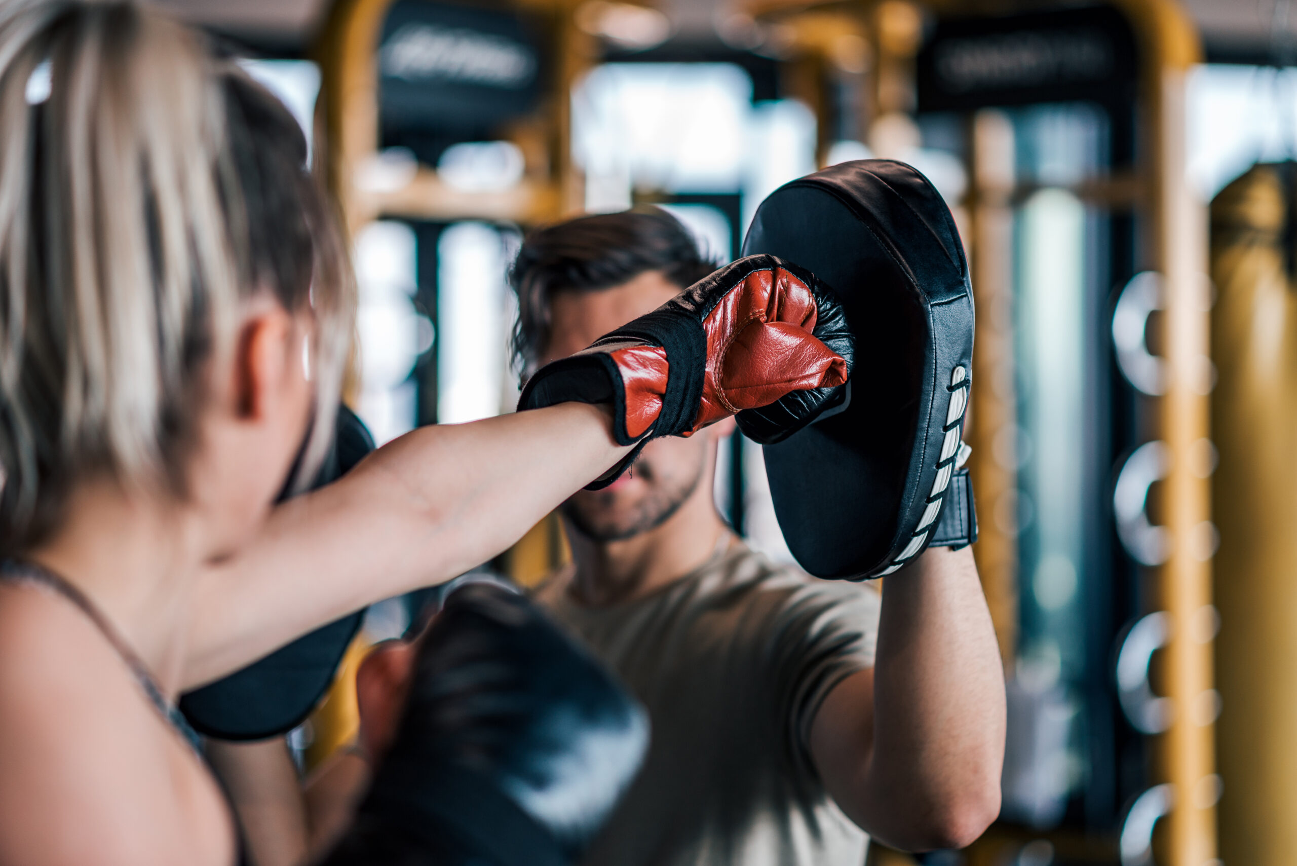 Woman boxer hitting the glove of her sparring partner, close-up. boxing training